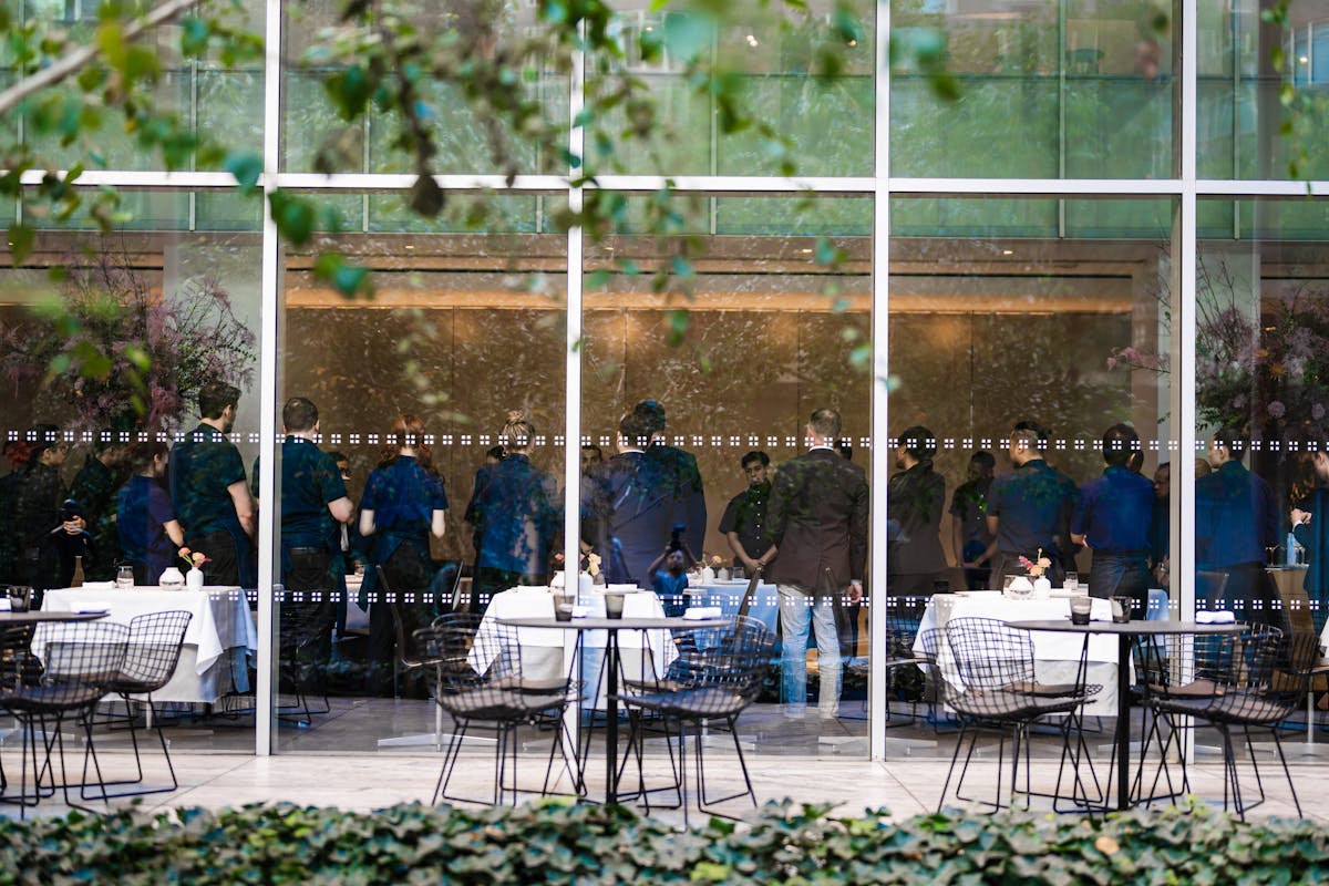 a group of people sitting in a chair in front of a fence