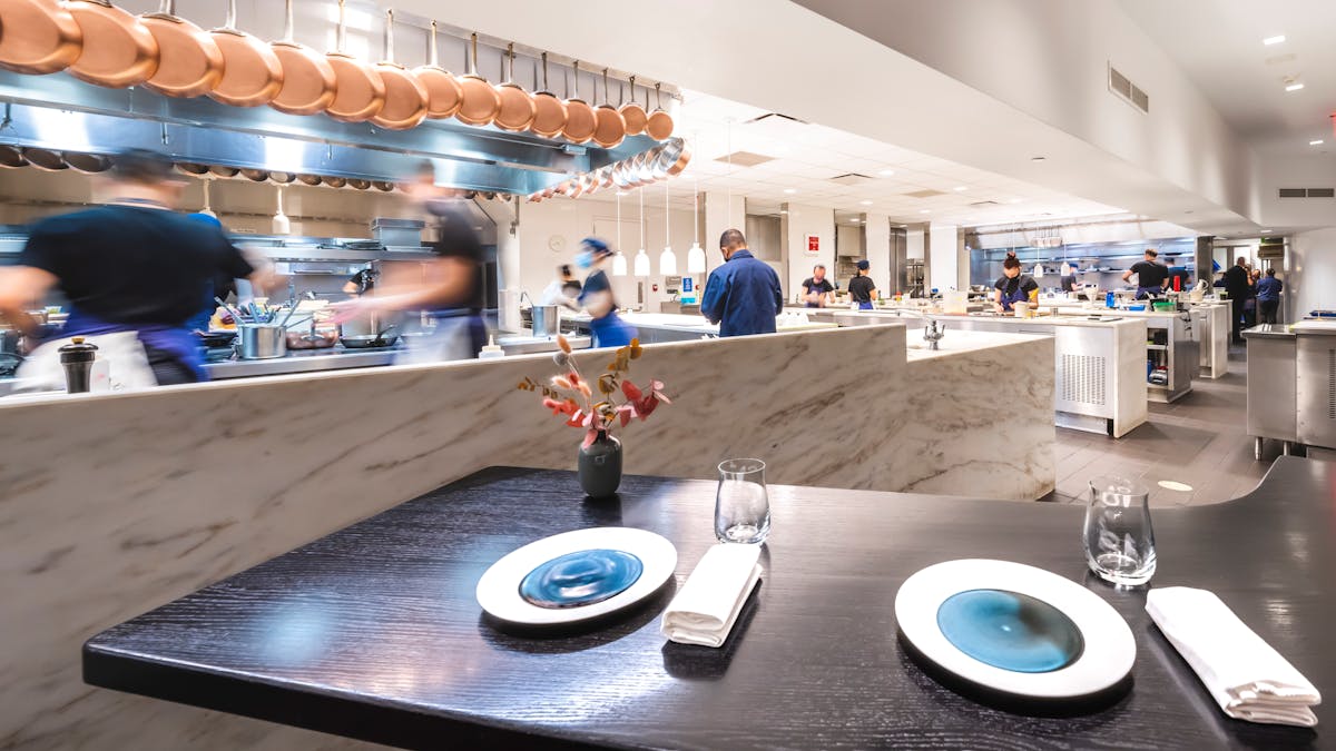 a group of people sitting at a table in a kitchen